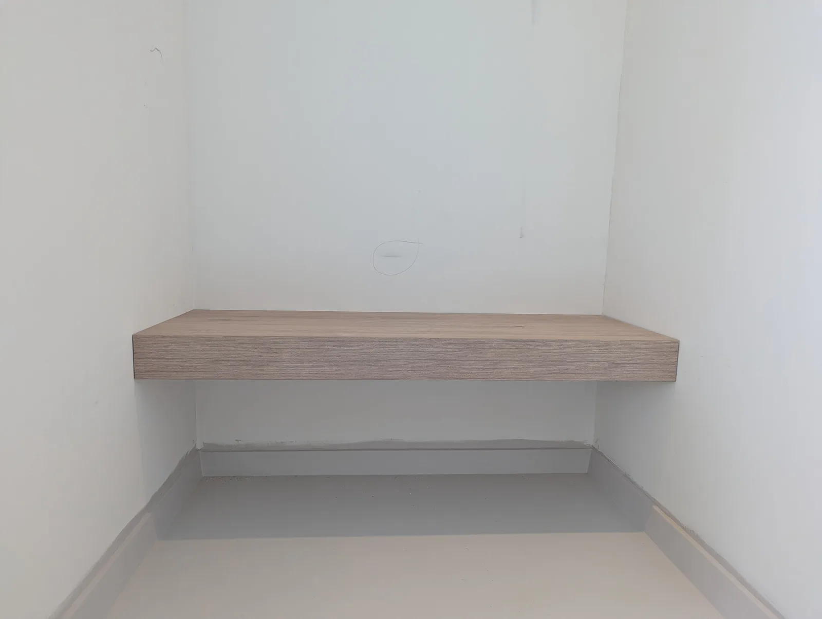 Zwevende houten bank op maat in een praktijkruimte